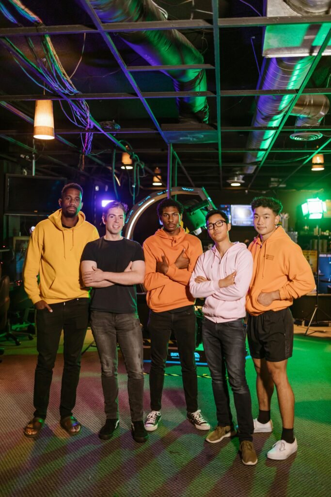 A group of diverse adult gamers standing confidently in an arcade environment, highlighting teamwork and e-sports culture.